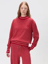 Sweater de tejido de punto jacquard con diseño geométrico, cuello redondo y puños acanalados en contraste de color verde y beige.