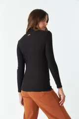 Remera de manga larga y cuello alto, confeccionada en tejido de punto acanalado color negro.