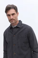 Sobrecamisa de canvas resistente con efecto lavado, cuello clásico, cierre frontal con botones y bolsillo en el pecho.