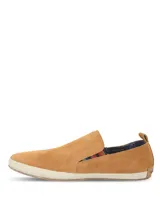 Alpargata Hush Puppies de gamuza color mostaza, con suela de yute trenzado y detalle de elástico lateral con diseño multicolor. Cuenta con forro interior de algodón orgánico.