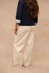 Pantalón de corte ancho, color crudo, con bolsillos delanteros aplicados y costuras pespunteadas a contratono.