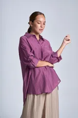 Camisa negra de tela traslúcida con cuello clásico, cierre frontal con botones y dos bolsillos de parche en el pecho.