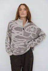 Buzo de tejido de punto con cierre frontal, cuello alto y diseño estampado en tonos beige y marrón.