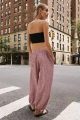 Pantalón bombacho con estampado de cuadros vichy en color rojo y blanco, cintura elástica con cordón de ajuste y puños elásticos en los tobillos.