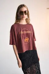 Remera corta color borgoña con estampa de un tigre y el nombre de la ciudad de Palermo en color naranja.