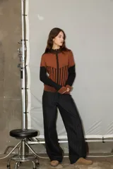 Campera de punto con cierre frontal, diseño bicolor en tonos bordó y rojo, con mangas largas y textura combinada de tejido liso y acanalado.