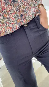 Pantalón de corte wide leg en color azul marino, con tiro medio-alto, cierre frontal con botón metálico decorativo y bolsillos laterales.