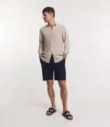 Bermuda masculina de sarga color azul marino, con cintura elástica, cordón ajustable y bolsillos traseros.