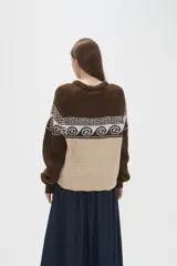 Sweater de tejido de punto con diseño jacquard, cuello redondo y mangas largas. Presenta una combinación de bloques de color azul marino y celeste con un patrón geométrico en la parte superior.