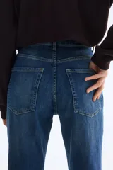 Jean de cinco bolsillos en denim de algodón con liviano stretch para una comodidad óptima, de corte ajustado en cintura y cadera, pierna bootcut y tiro alto con cierre y botón.