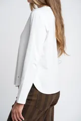 Remera de manga larga con cuello redondo, confeccionada en tejido de algodón con elastano, de calce ajustado al cuerpo.