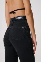 Pantalón de jean negro de tiro alto, corte flare y pretina con trabillas. Confeccionado en denim 100% algodón.