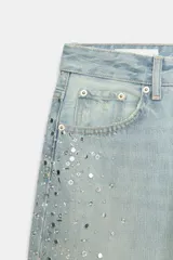 Jeans baggy de tiro medio, pierna ancha y diseño de cinco bolsillos, confeccionados en denim celeste con aplicaciones de brillos en los laterales.