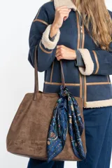 Pañuelo cuadrado de poliéster con estampado floral en tonos azules, verdes y marrones. Presenta un diseño clásico con bordes definidos.