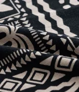 Camisa de hombre marca Blue Steel, modelo relaxed, confeccionada en tricolina de algodón. Presenta manga corta, cuello inglés, cierre frontal con botones y un bolsillo de parche. El diseño destaca por su estampado abstracto de verano con motivos de palmeras en color beige sobre fondo negro.