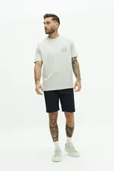 Bermuda de gabardina azul marino con logo bordado, bolsillos laterales y traseros, cierre con cremallera y botón, y presillas para cinturón.