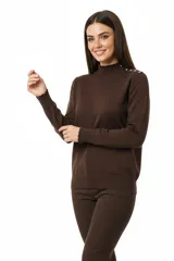 Polera de tejido acanalado color beige, con cuello alto y detalle de botones decorativos en el hombro. De corte ajustado al cuerpo y manga larga.