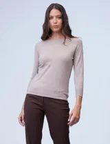 Buzo de tejido fino, color beige, con cuello redondo, mangas tres cuartos y diseño raglán.