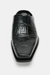 Zueco negro de piel con acabado grabado efecto cocodrilo, diseño destalonado, punta cuadrada y tacón ancho.