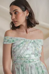 Vestido largo de gasa de seda natural estampada en tonos blanco, verde y amarillo. Diseño drapeado con escote barco y manga caída, falda con movimiento y tajo lateral.