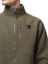 Campera de polar negro con cuello alto y cierre frontal completo. Presenta paneles de nylon en contraste en el pecho, hombros y codos, incluyendo un bolsillo vertical con cierre en el pecho y dos bolsillos laterales abiertos.