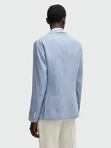 Blazer de corte estructurado en tono celeste con textura sutil, cierre frontal de dos botones, solapas clásicas y bolsillos de parche.