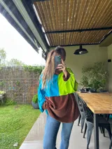 Polerón oversize con bloques de color lila, verde agua y negro.