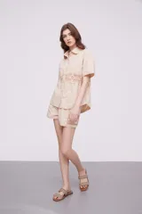 Camisa blanca de algodón con apliques de crochet calado en la cintura, manga corta y cuello camisa.