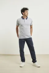 Chomba de piqué azul con cuello clásico, mangas cortas y corte recto. El cuello y los puños tienen detalles a contratono en azul marino y blanco.