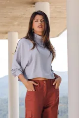 Blusa celeste con cuello alto, mangas 3/4 abullonadas y corte cropped.