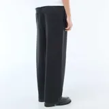 Pantalón de corte ancho y estilo jogging, confeccionado en tejido liso de color negro, con cintura elástica y diseño minimalista.