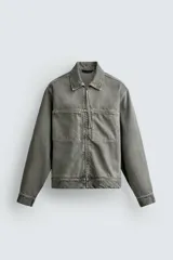 Sobrecamisa de corte regular fit confeccionada en denim de algodón con efecto lavado. Presenta cuello solapa, cierre frontal con cremallera, bolsillos de plastrón en el pecho y mangas largas con puños abotonados.