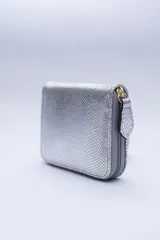 Billetera marrón tipo sobre con cierre de cremallera, confeccionada en cuero con textura tipo cocodrilo y forro textil rojo. Cuenta con múltiples ranuras para tarjetas, documentos y billetes.