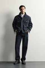 Pantalón jeans straight fit de tiro bajo, confeccionado en denim de algodón oscuro sin lavados, con diseño de pierna recta, cinco bolsillos y cierre frontal de botonadura.