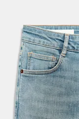 Jeans de tiro alto con corte skinny y largo tobillero. Presenta diseño clásico de cinco bolsillos, cierre frontal con cremallera y botón, con un acabado de lavado azul medio.