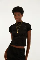 Top negro entallado de manga corta con cuello alto y textura sutil de diseño floral.
