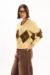 Sweater de punto con escote en V y calce relajado, con diseño de rombos en color bordó y celeste.