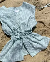 Blusa verde con rayas blancas, fruncida con ataduras en el frente y en los hombros.