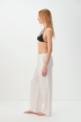 Pantalon de corte recto y holgado, confeccionado en una mezcla de lino y algodón. Presenta una cintura elástica con cordón ajustable y bolsillos laterales.