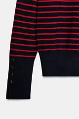 Sweater de punto liso con diseño a rayas horizontales, cuello redondo rojo y mangas largas terminadas en puños con botones dorados decorativos.