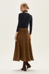 Falda midi acampanada de color camel, confeccionada en material con textura similar al cuero gamuzado.