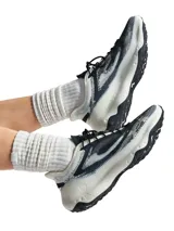 Championes deportivos Under Armour UA Flare en color blanco y negro, con capellada textil transpirable, entresuela acolchada de gran volumen y suela de goma resistente.