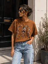 Remera marrón de algodón con cuello redondo, mangas cortas y estampa frontal de estilo místico con un corazón, un ojo y serpientes.