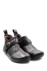 Bota baja de cuero color marrón, estilo botín con elásticos laterales y tira con hebilla metálica ajustable. Cuenta con costuras decorativas pespunteadas y suela de goma con relieve.