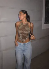 Top halter con lentejuelas en tonos dorados y marrones, con diseño en punta en el dobladillo inferior y tirantes regulables para atar al cuello y la espalda.