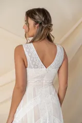 Vestido largo de tul color nude con apliques de encaje blanco y corte irregular.