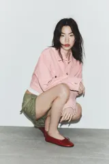 Cazadora de denim en color rosado, con cuello solapa, manga larga y cierre frontal con botones metálicos. Presenta bolsillos con solapa y botón en el pecho, además de trabillas en la cintura.