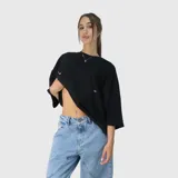 Remera negra de corte oversize con mangas cortas amplias y cuello redondo. Presenta un pequeño estampado minimalista en color blanco en el pecho.