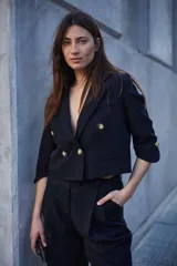 Pantalón de corte sastrero color beige, de tiro alto, con pinzas y largo al tobillo.