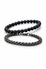 Set de dos pulseras para hombre, una compuesta por cuentas esféricas negras y la otra de cadena metálica trenzada en color gris oscuro.